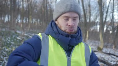 Güzel bir karlı ormanda parlak yansıtıcı yelek giyen bir birey kış boyunca doğayla derin bir ilişki içindedir.