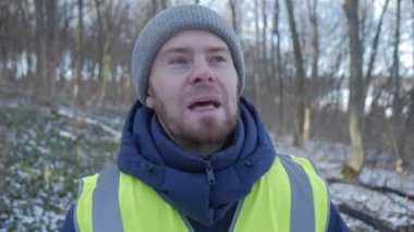 Güzel bir karlı ormanda parlak yansıtıcı yelek giyen bir birey kış boyunca doğayla derin bir ilişki içindedir.