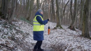 Güzel bir karlı ormanda parlak yansıtıcı yelek giyen bir birey kış boyunca doğayla derin bir ilişki içindedir.