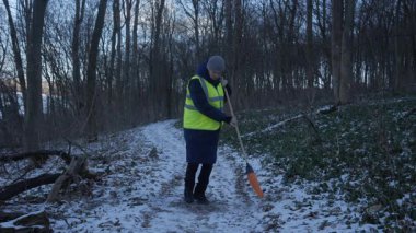 Güzel bir karlı ormanda parlak yansıtıcı yelek giyen bir birey kış boyunca doğayla derin bir ilişki içindedir.