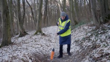 Güzel bir karlı ormanda parlak yansıtıcı yelek giyen bir birey kış boyunca doğayla derin bir ilişki içindedir.