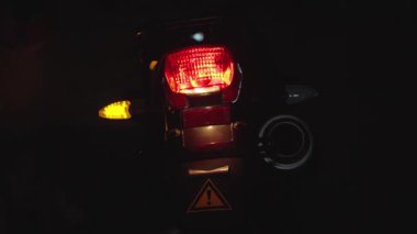 Motosikletlerin arka ışıkları, karmaşık tasarım ve geceleri güzelce aydınlatılan özellikler.