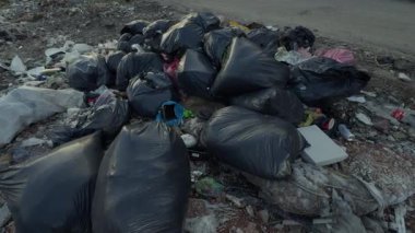 A significant accumulation of various types of trash and bags clearly indicating poor waste disposal practices