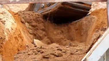 Kazıcı kamyonun arka tarafına ağır bir kovayla toprak naklediyor. Yüksek kaliteli FullHD görüntüler