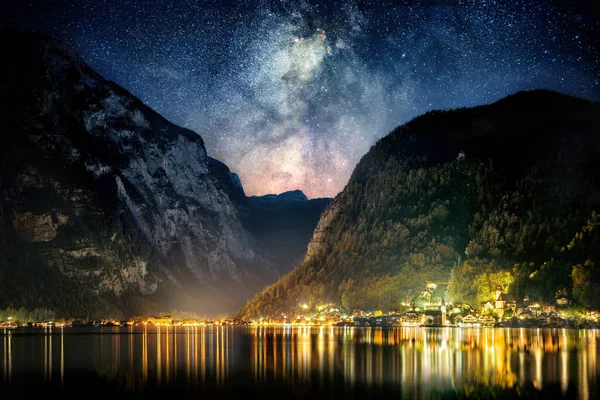 Night sky with the Milky Way and mountains over the iconic town of Hallstatt in Austria, Europe