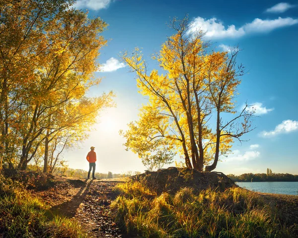 Mann Steht Seeufer Und Genießt Die Malerische Landschaft Der Herbstsonne Stockfoto