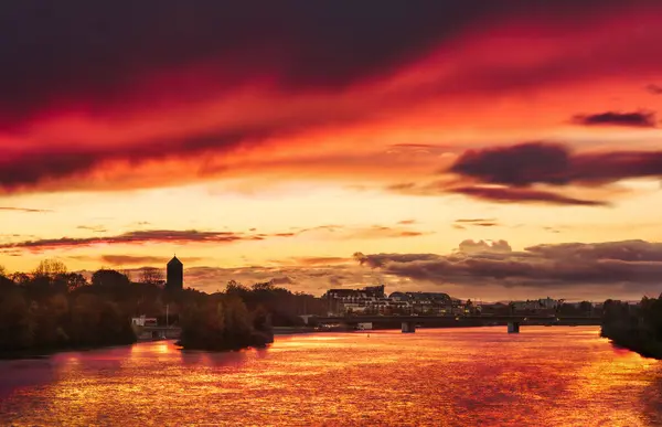 ドイツ ハイデルベルクのネッカール川を渡るロマンチックな景色 夕日における劇的な赤い空 ロイヤリティフリーのストック写真
