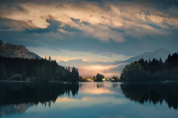 夜晚的风景 明亮的云彩映衬在湖中 蓝黄相间的宁静的高山风景 免版税图库照片