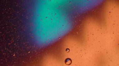 Karışık su ve yağ zemininde mikro baloncuklar, renkli soyut turuncu - yeşil - sarı uçlu ışıklar, süper makro soyutlama arka planı