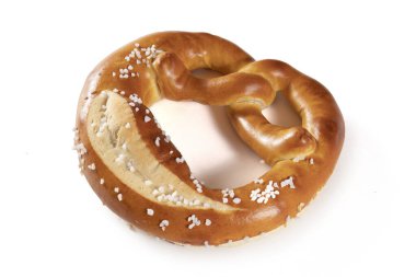 Beyaz arka planda tuzlu Bavyera krakeri. Kraker düğüm şeklinde ve bol miktarda tuzla kaplı. Çubuk kraker kahverengi ve çıtır çıtır ve lezzetli görünüyor..