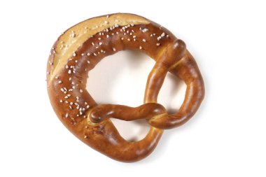 Beyaz arka planda tuzlu Bavyera krakeri. Kraker düğüm şeklinde ve bol miktarda tuzla kaplı. Çubuk kraker kahverengi ve çıtır çıtır ve lezzetli görünüyor..