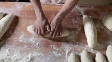 Becerikli bir fırıncı, geleneksel ekmek yapımının özünü yakalayarak, rustik hamur somunu ustalıkla şekillendirir.