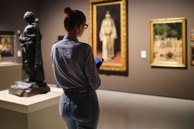 Müzedeki kadınlar sanat sergilerine bakarlar.