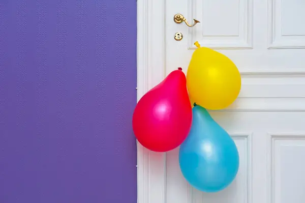 Białe Drewniane Drzwi Ozdobione Trzema Kolorowymi Balonami — Zdjęcie stockowe