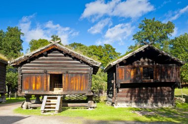 OSLO, NORWAY - AUGUST 29, 2016: Storehouse from Troym ( ca. 1650 - 1700 ) and Goat shed from Halvorsgard ( 1700 - 1800 ) in Norwegian Folk Museum (The Norwegian Museum of Cultural History) in Oslo. clipart