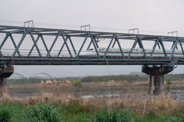 SHIZUOKA, JAPONYA - 6 Nisan 2023: Tokaido Shinkansen Fuji View Shinkansen demiryolu köprüsünü geçerken