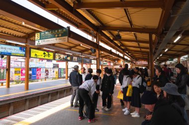 KAMAKURA, JAPONYA - 8 Kasım 2024: Kamakura istasyonunda tren bekleyen yolcular