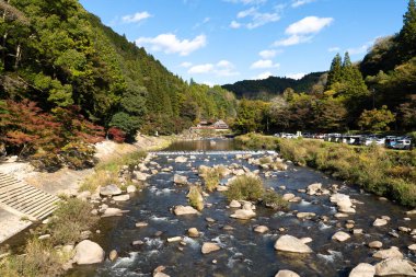 Sonbahar mevsimi boyunca Korankei boğazındaki Kaorukaede köprüsünden Tomoe nehri manzarası