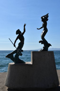 PUERTO VìRTA, MEXICO - 11 Nisan 2023 'te Carlos Espino tarafından Puerto Vallarta, Meksika' daki Malecon 'da yapılan Triton y Sirena heykeli.