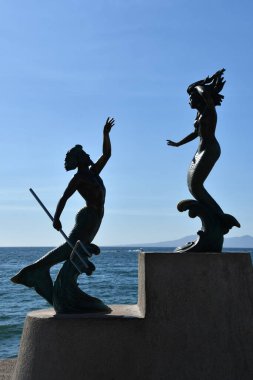 PUERTO VìRTA, MEXICO - 11 Nisan 2023 'te Carlos Espino tarafından Puerto Vallarta, Meksika' daki Malecon 'da yapılan Triton y Sirena heykeli.
