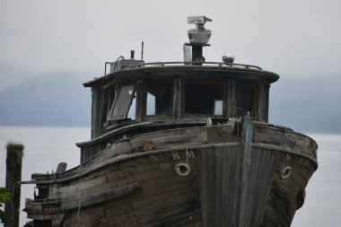 ICY STRAIT, ALASKA - 24 Ağustos 2023 'te ABD' nin Alaska kentindeki Hoonah yakınlarındaki Icy Boğazı 'nda terk edilmiş küçük bir balıkçı teknesi.