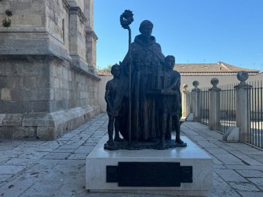 ALCALA DE HENARES, SPAIN - AUG 14: Statue of Cardinal Cisneros and the Santos Ninos at Magistral Cathedral of Saint Justus and Saint Pastor in Alcala De Henares, near Madrid, in Spain, as seen on Aug 14, 2024. clipart