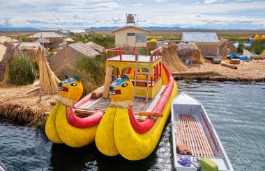 Uros, Peru - 09 Ocak 2022: Titicaca Gölü kıyısında yüzen bir adanın açığında turist botu.