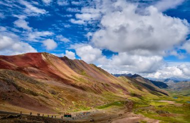 Tourists go to Mount Vinicunca in the Peruvian Andes. Picturesque mountain landscape.