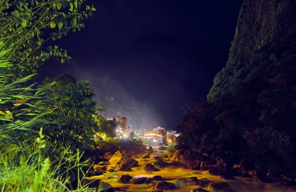 夜晚在安第斯山脉的一个小镇上的山河 Aguas Calientes 图库图片