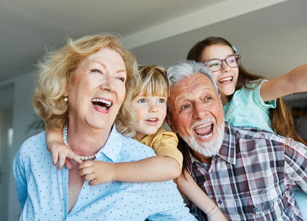 Portrait of grandparents and grandchildren having fun together at home