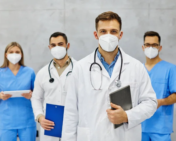 Portrait of a group of doctors and health care workers wearing protective masks in the office hospital