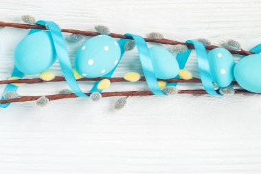 Beyaz arka planda Paskalya yumurtası ve söğüt dalları, üst görünüm