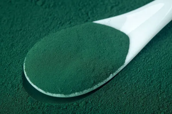 セラミックスプーンで緑色のクロレラとスピルリナ粉末 上記のビューから選択的な焦点 — ストック写真