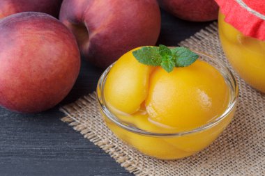 Kavanozların eski siyah ahşap masa (seçici odak içinde yarım şeftali ile Şeftali Kompostosu).