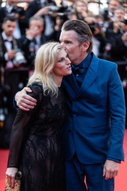 CANNES, FRANCE - MAY 21, 2022: US actor and writer Ethan Hawke and his wife US producer Ryan Hawke kiss as they arrive for the screening of the film 