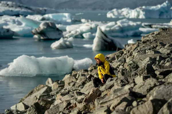 Sarı Ceketli Gezgin Cep telefonuyla Kuzey Kutbu Sahnesinin tadını çıkarıyor
