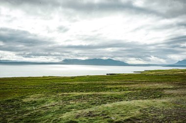 Bulutlu Gökler Altında Dağ Manzaralı Huzurlu Lakeside Kayalıkları