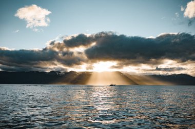 Güneş ışığı Bulutları delip geçiyor Alacakaranlık 'taki Dağ Gölü' nün üzerinde