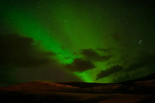 stock image Majestic Green Aurora Borealis Over Silhouetted Hills at Night