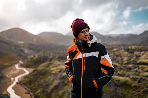 Siyah ceketli maceraperest yürüyüşçü Dağ manzarasını keşfediyor.