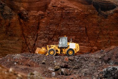 Kırmızı kum veya kil arkaplanda sarı traktör
