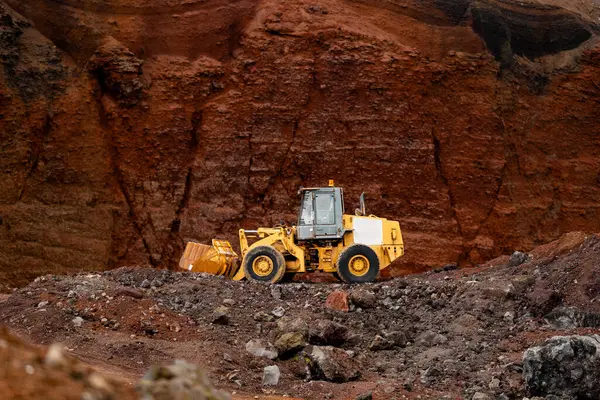 Kırmızı kum veya kil arkaplanda sarı traktör