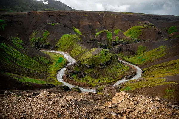 stock image Meandering River Through Lush Green Valley with Steep Hills