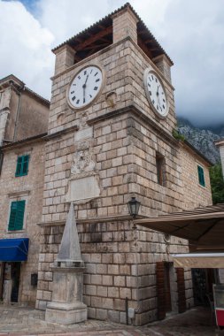 Kotor 'daki 17. yüzyıl saat kulesinin önünde bir ortaçağ pillorisi duruyor.