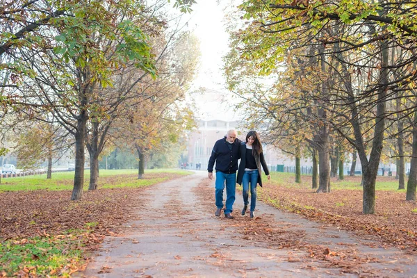 大人の父と娘が一緒に秋に屋外で腕を歩いてリラックス — ストック写真