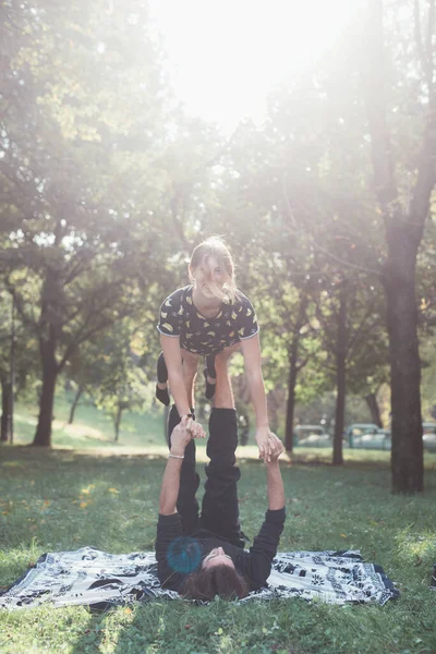 Friska Ung Man Liggande Gräs Och Balanserande Kvinna Gör Akrobatisk — Stockfoto