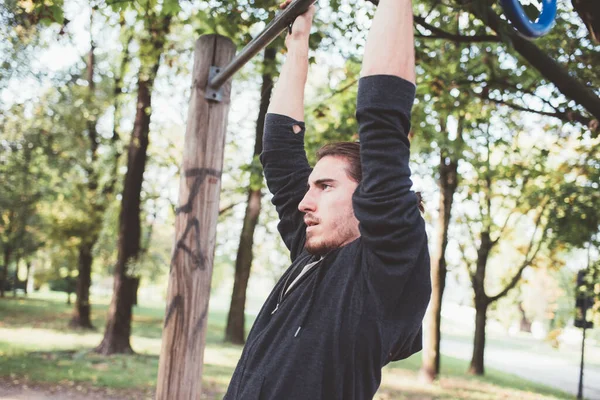 スポーツマンが屋外の設備の整った公園で運動トレーニングワークアウトを引き上げる — ストック写真