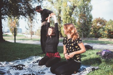 Küçük bir grup atletik genç dışarıda parkta yoğun antrenmana hazırlanıyor.