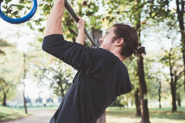 スポーツマンが屋外の設備の整った公園で運動トレーニングワークアウトを引き上げる — ストック写真
