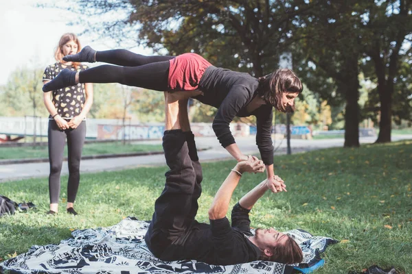 Couple acrobatic contortionist practicing gymnastic yoga outdoors